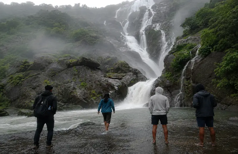 Dudhsagar Falls in Goa with Visitors Standing Near the Base of the Majestic Multi-Tiered Waterfall
