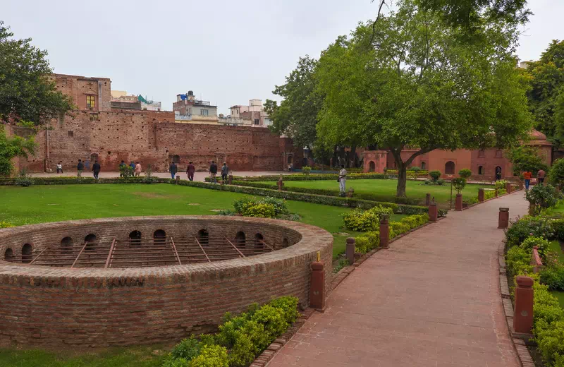 Quiet memorial garden at Jallianwala Bagh in Amritsar with visitors walking through the grounds