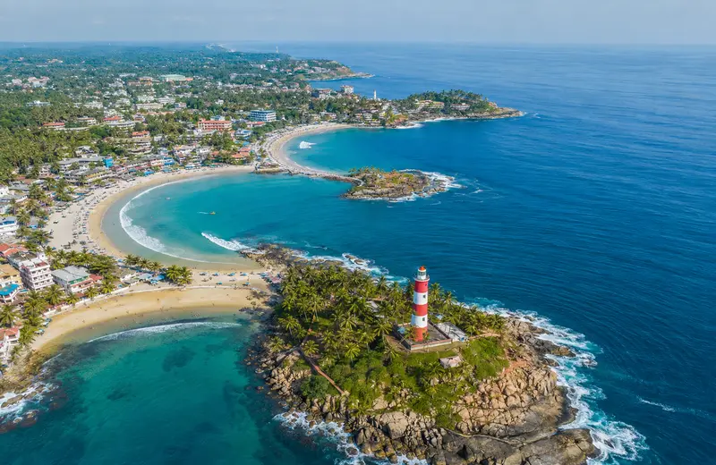 Kovalam Beach in Kerala showing the three crescent coves and the Vizhinjam Lighthouse