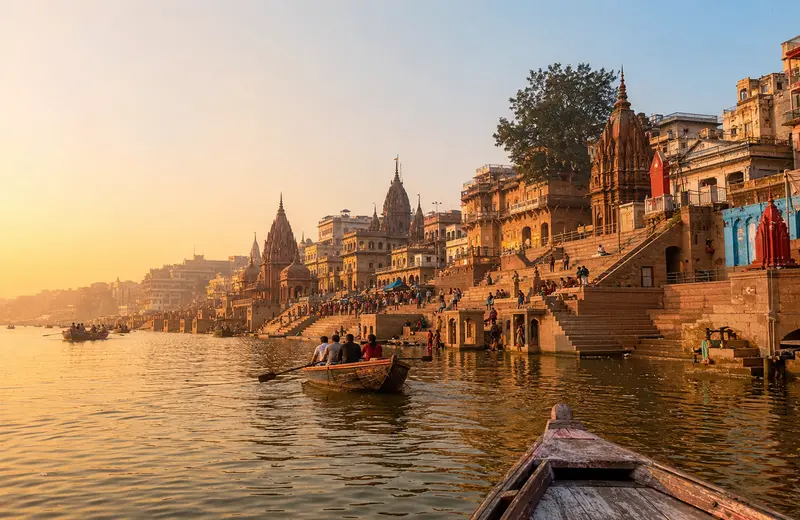 Panoramic view of Varanasi ghats and temple spires along the Ganga River at sunrise