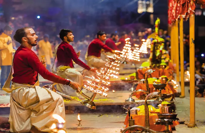 Priests performing the evening Ganga Aarti with multi-tiered brass lamps at Dashashwamedh Ghat, Varanasi