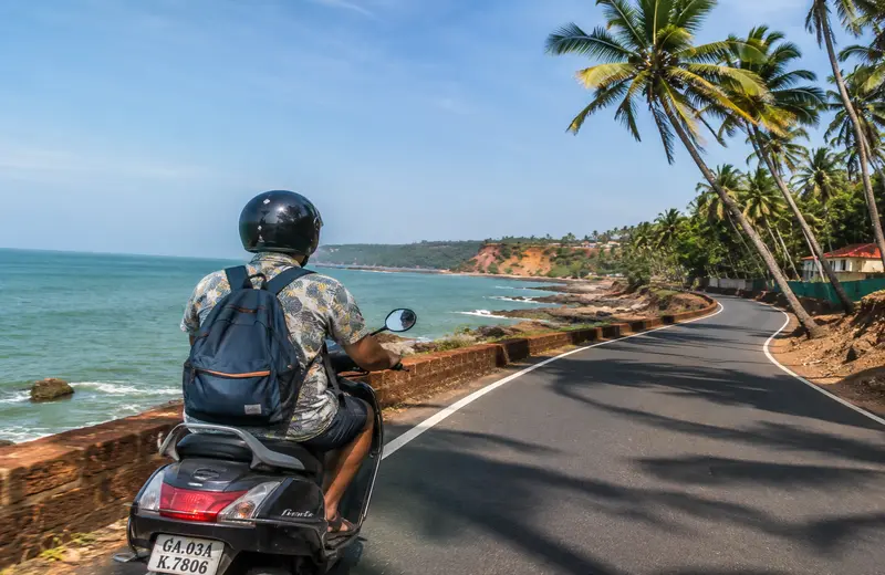 Exploring Goa on a scooter along a coastal road past the Arabian Sea