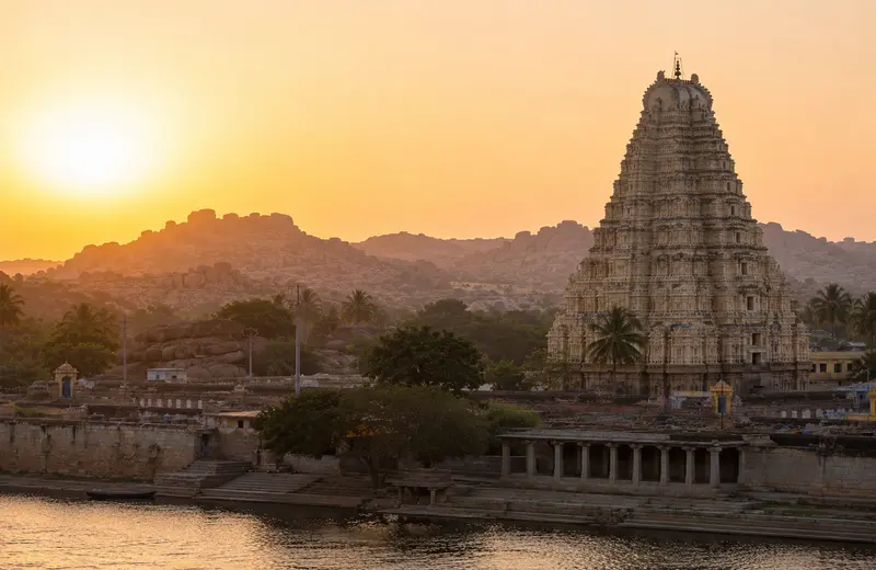 Virupaksha Temple tower at sunrise beside the Tungabhadra River, Hampi