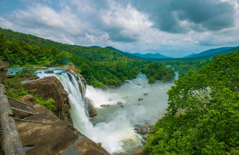 Athirapally Falls in full flow during monsoon season – lush greenery and mist
