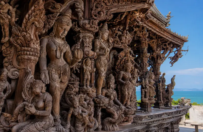 Hand-carved teak deities covering a wing of the Sanctuary of Truth temple in Thailand