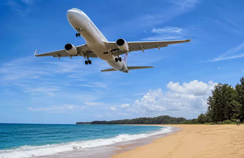 Passenger jet descending low over Mai Khao Beach near the Phuket airport runway