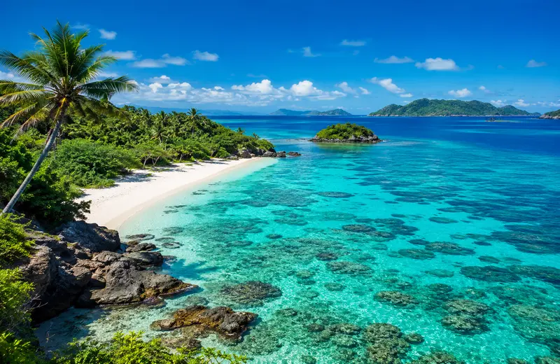 Tropical beach with crystal-clear turquoise water in the Fiji Islands.